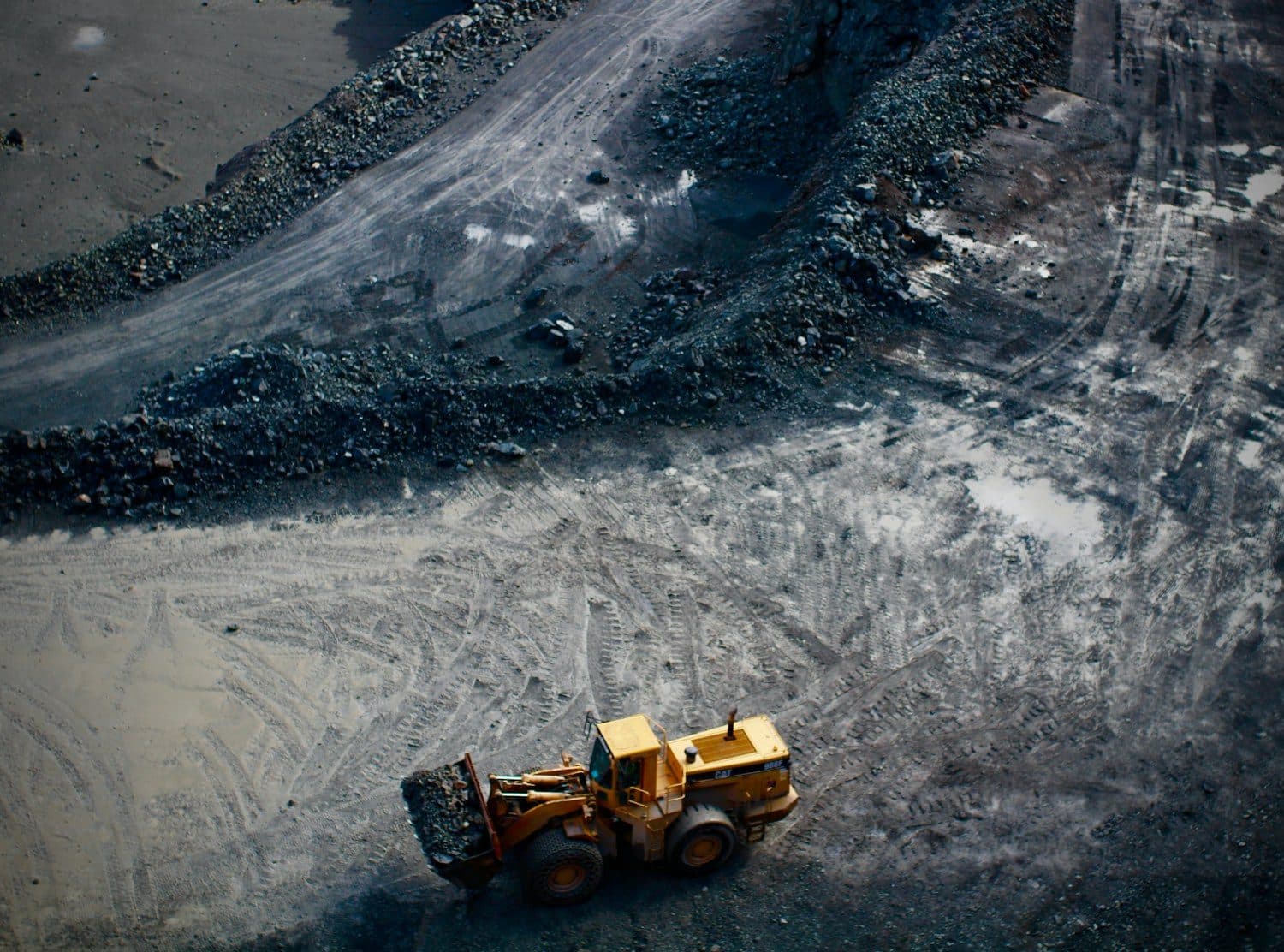 Wheel loader working a rock cut from above